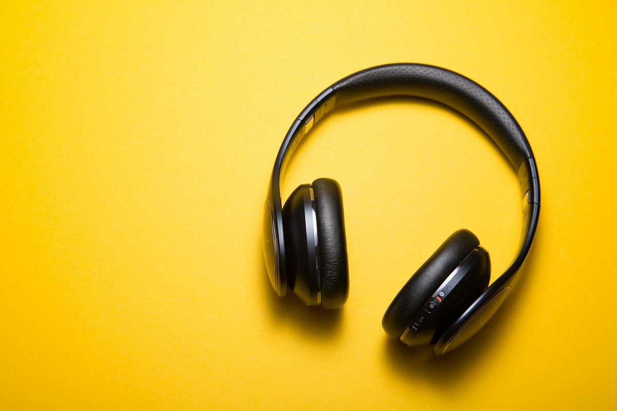 Premium over-ear headphones on minimal wooden desk surface