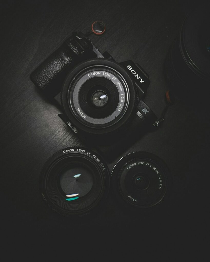 Classic compact camera next to printed photo album on wooden table