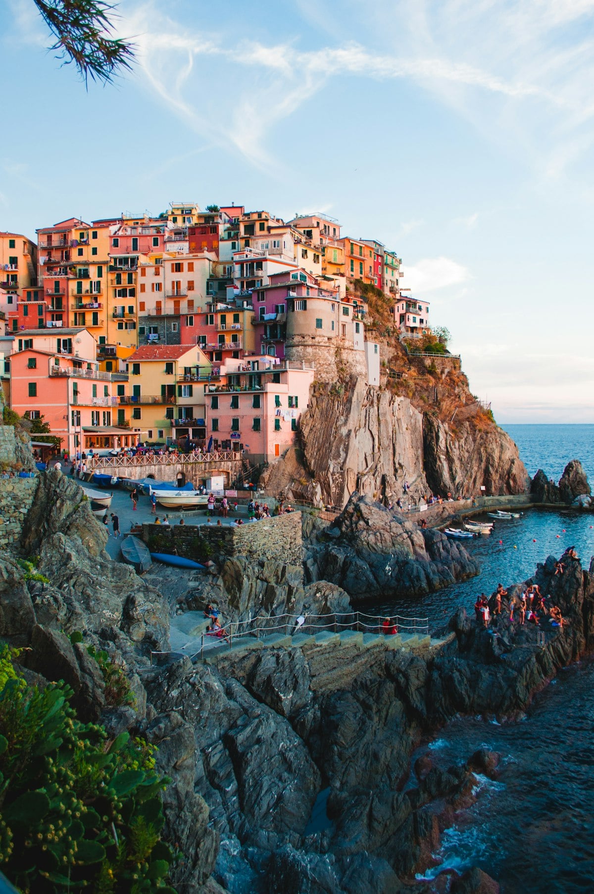 Picturesque Mediterranean cliffside coastal village with pastel stone houses overlooking azure sea