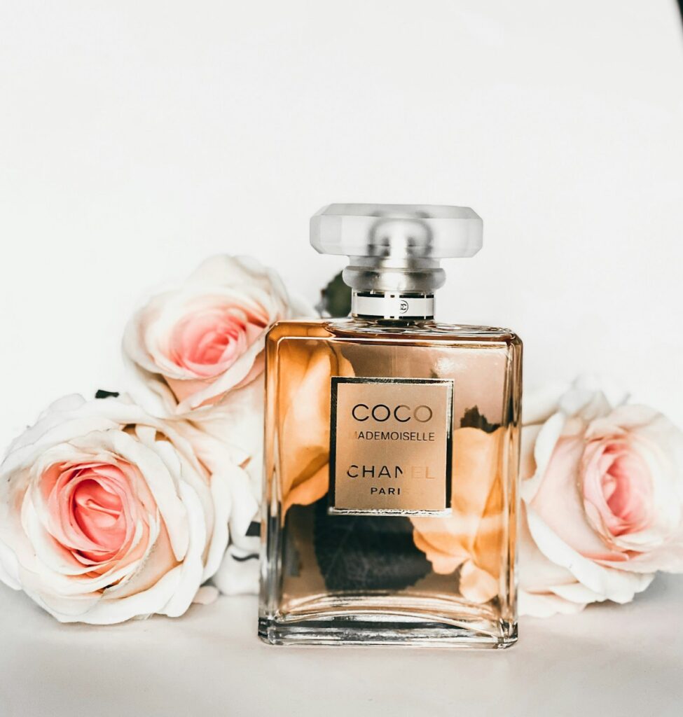 Artisanal glass perfume bottle with natural light reflection and gold fragrance mist