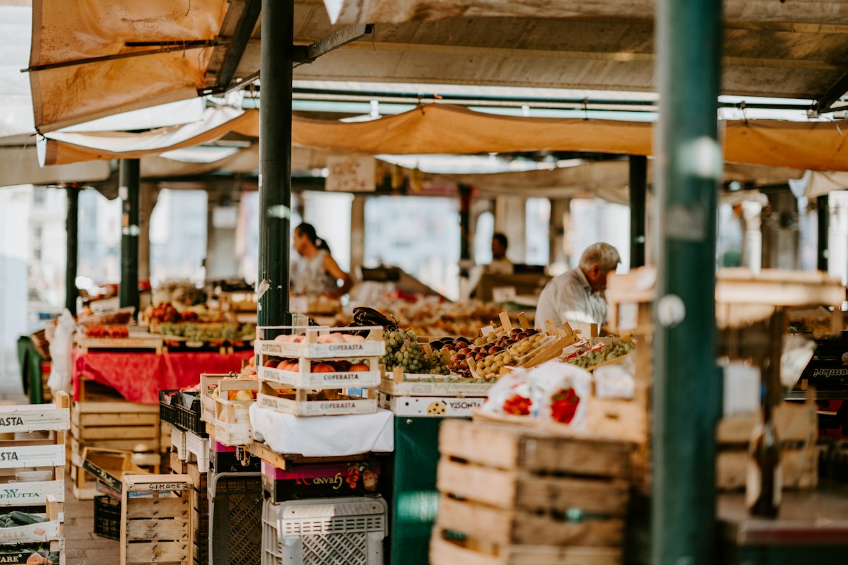 Vibrant open-air market with fresh organic fruits, flowers, and artisanal bakery goods